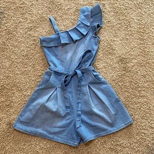 Habitual light denim romper. Asymmetric shoulder w/ ruffle. Pockets & belt
